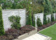 Espaliered camellias onto fence panels (look like living pieces of art) framed by upright buxus and a beautiful skirt of burgand